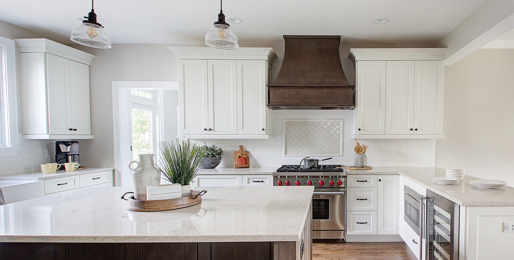 Bright white kitchen with a long island and open shelving