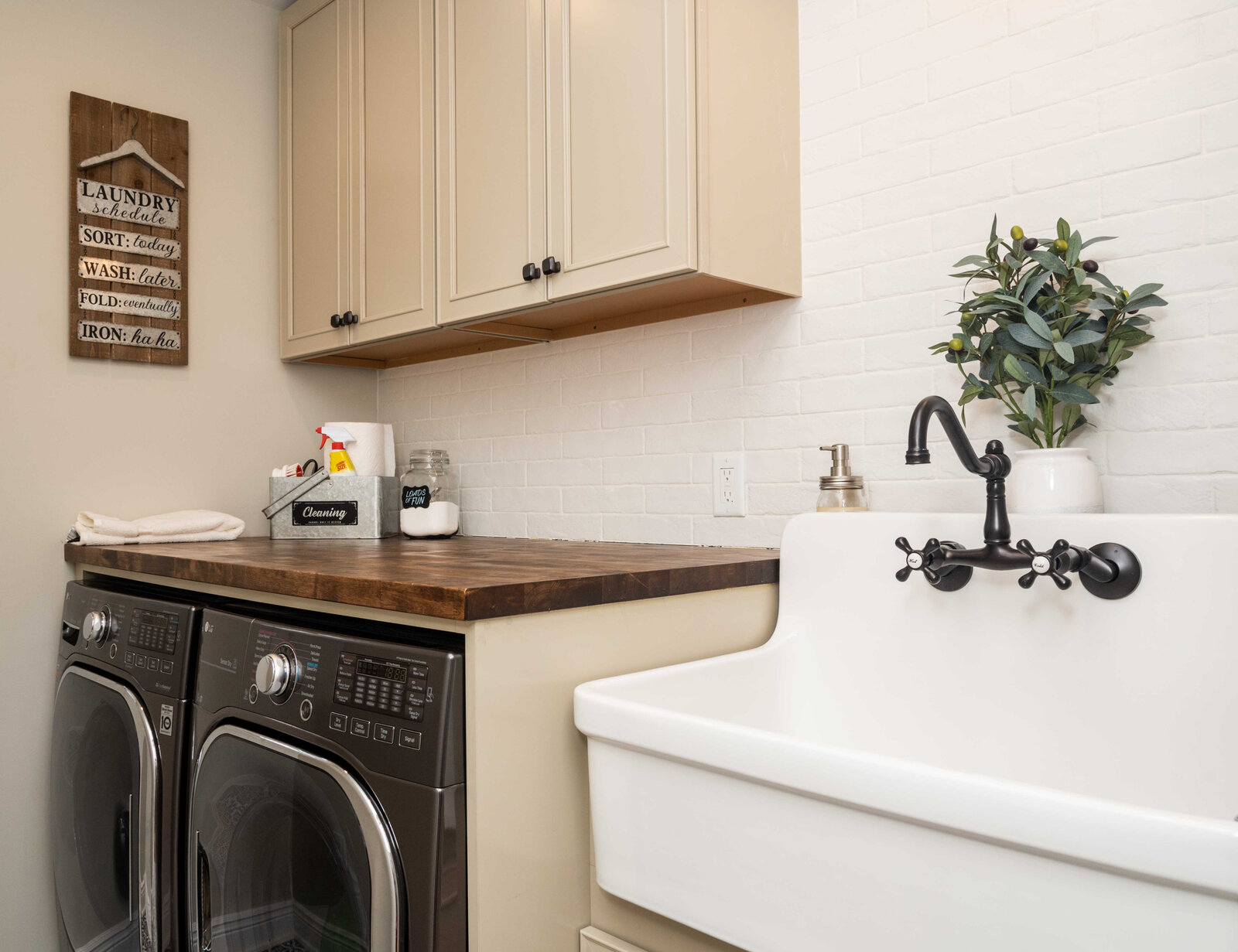 Laundry room sink with white cabinetry and patterned tile