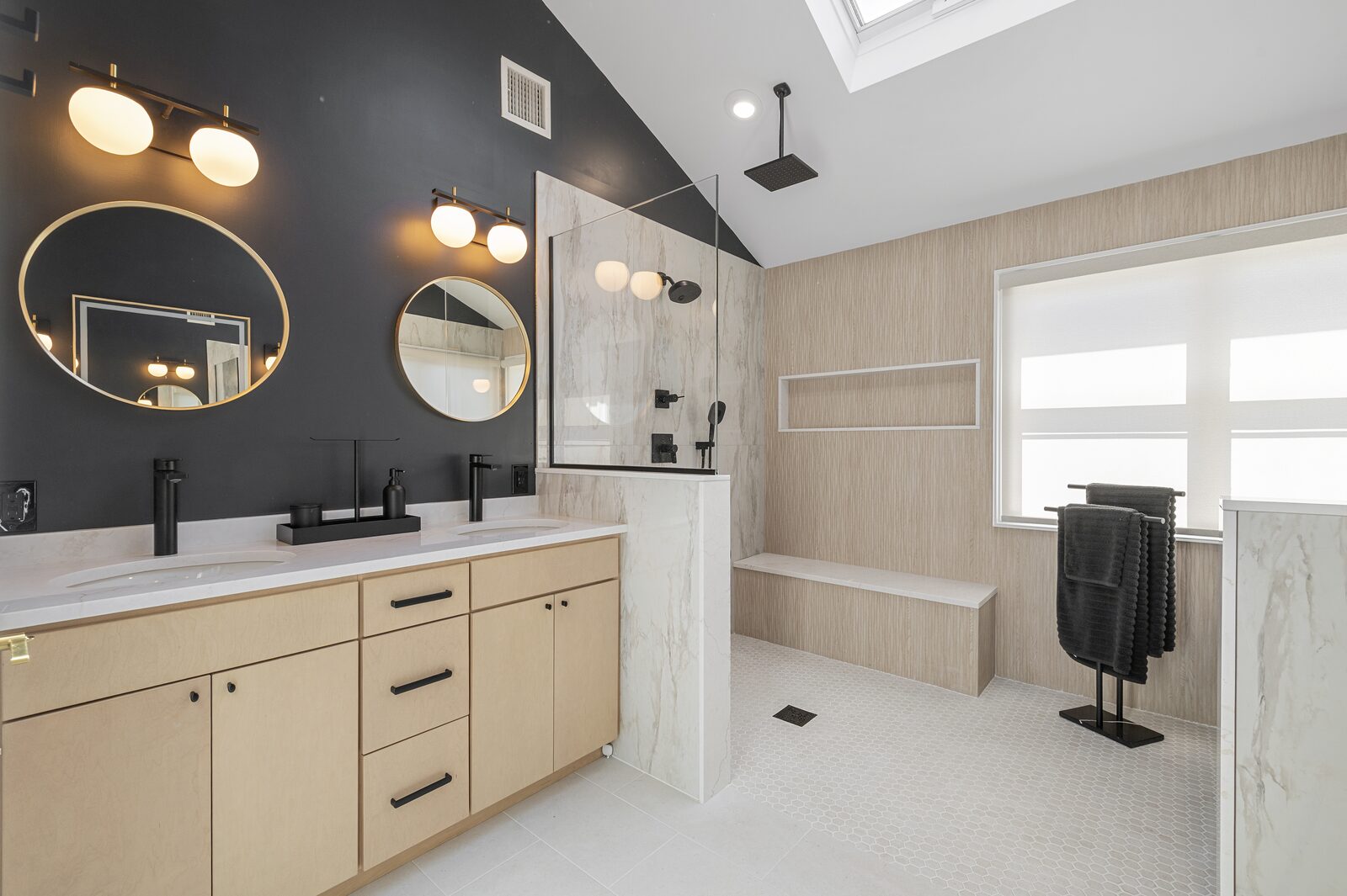 Light wood vanity beside a glass shower