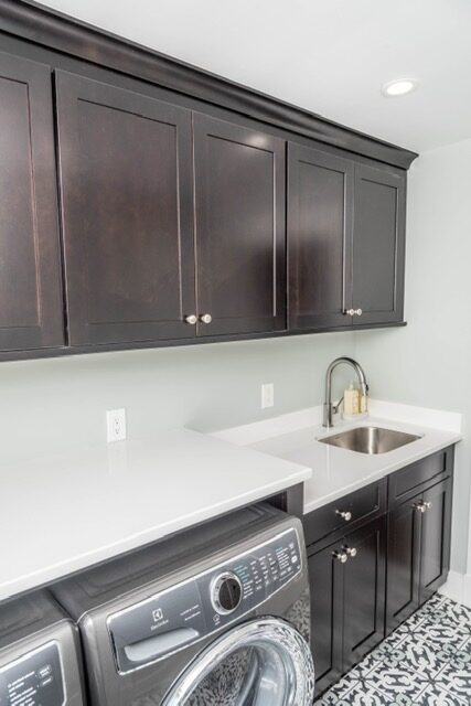 Dark laundry cabinets above a utility sink