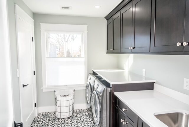 Compact laundry room with dark cabinetry